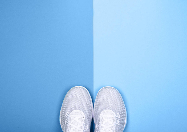 White sport shoes sneakers blue background with copy space. - Photo, Image