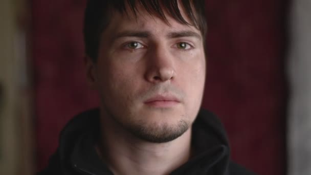 Zbliżenie emocjonalny portret młodego mężczyzny patrząc zły, marszczenie brwi i zrzędliwy - Materiał filmowy, wideo