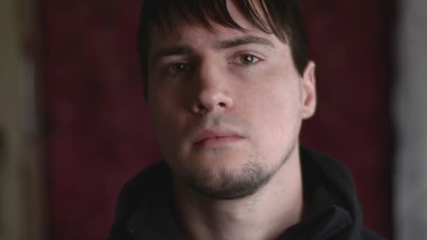 Közelkép érzelmi portré a fiatal férfi bámult, miközben vizsgálja a néző - Felvétel, videó