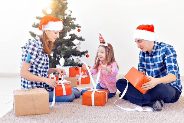 Концепция праздников и подарков - Портрет счастливой семьи, открывающей подарки на Рождество
 - Фото, изображение