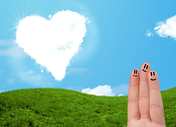 Happy smiley fingers looking at heart shaped cloud - Photo, Image
