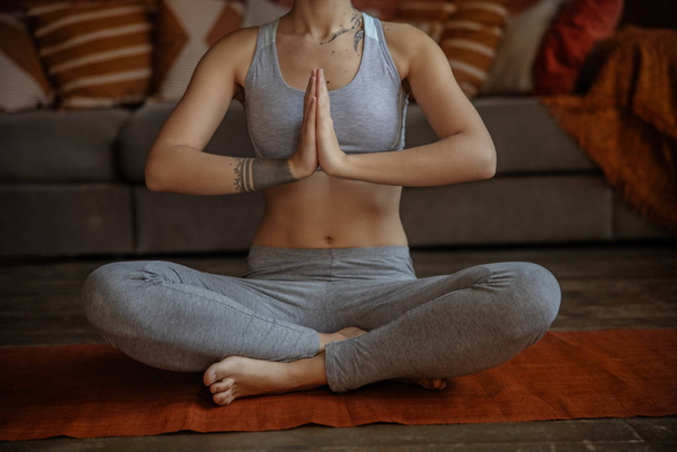 Close up of young woman sitting in lotus pose - Foto, imagen