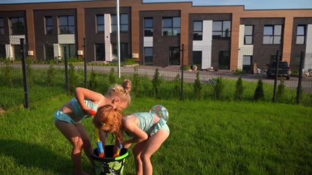 Naughty girls best friends water fight with toy guns. Sisters in swimsuits - Footage, Video