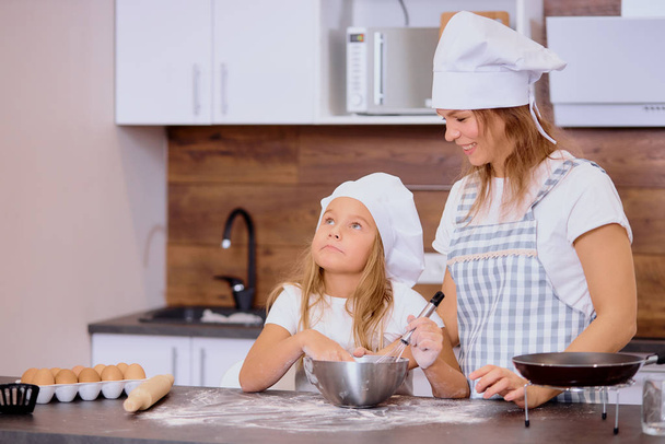 Happy caucasian mother and daughter baking together in the kitchen - Foto, Imagem