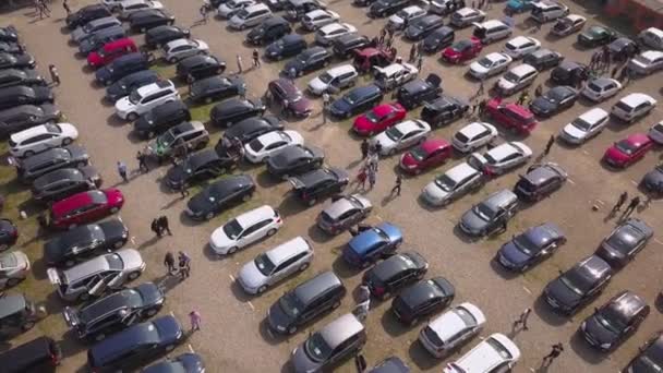 Vista superior aérea de muchos coches estacionados y clientes de personas caminando en el mercado de automóviles o estacionamiento. - Metraje, vídeo
