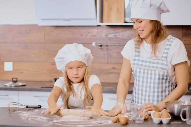 caucasian kid preparing dough at home, with mother - Foto, afbeelding