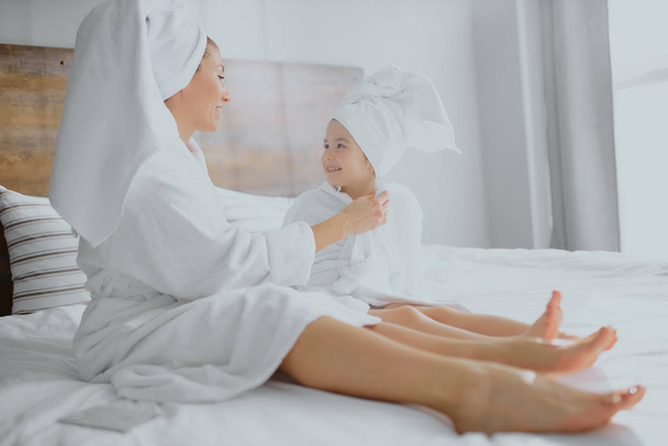 lovely family, mother and daughter lying on bed together after shower - Valokuva, kuva