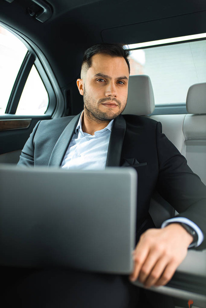 Portrait of young caucasian businessman inside expensive car - Foto, afbeelding