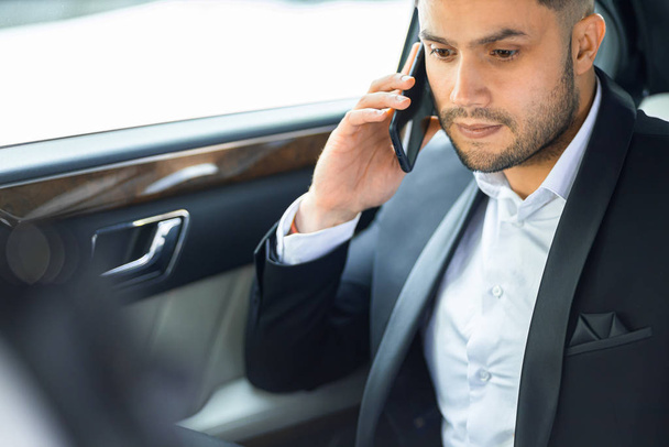 successful man talk on phone with his business colleague while riding in car - 写真・画像