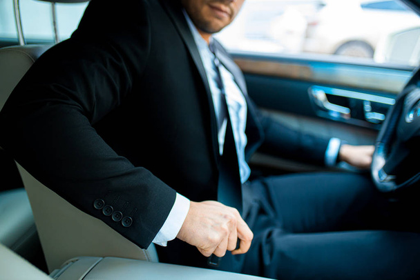 hombre joven recortado abrocharse el cinturón de seguridad en automóvil
 - Foto, Imagen