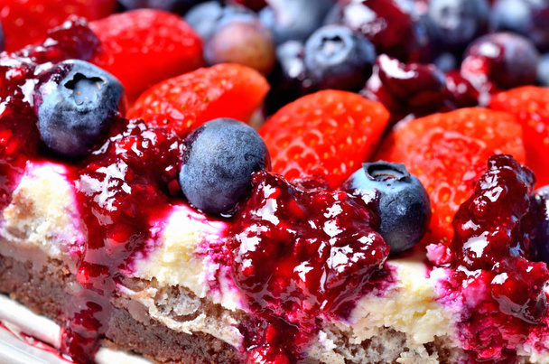 Makroszczegół ciasta serowego ze świeżymi truskawkami, jagodami i dżemem wiśniowym. - Zdjęcie, obraz