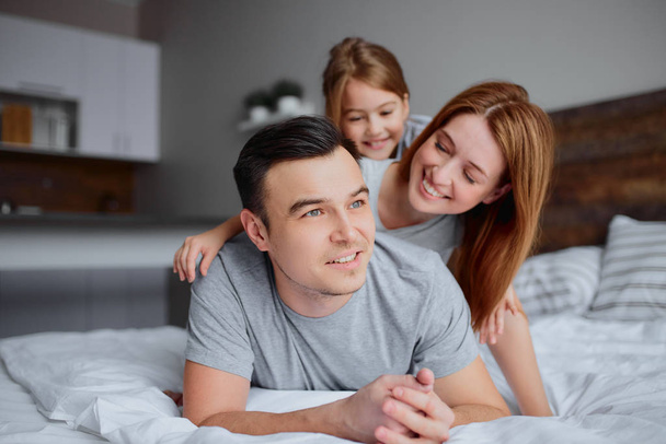 portrait of young family on bed - 写真・画像