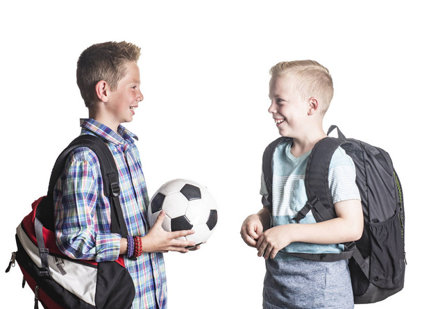 Due ragazzi sorridenti giocano insieme a scuola. Due amici che parlano insieme isolati su uno sfondo bianco - Foto, immagini