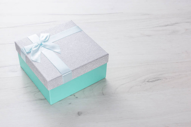 Φωτεινό ασημένιο και πράσινο κουτί δώρου με κορδέλα δώρου και φιόγκο - Φωτογραφία, εικόνα