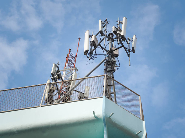 LTE, GSM, 2G, 3G, 4G, 5G wieża łączności komórkowej. Wieża telekomunikacyjna przeciwko błękitnemu niebu z chmurami. - Zdjęcie, obraz