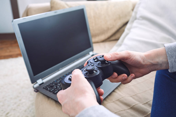 man holding joystick controllers while playing video games at home - Φωτογραφία, εικόνα