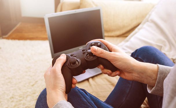 Mann hält Steuerknüppel, während er zu Hause Videospiele spielt - Foto, Bild