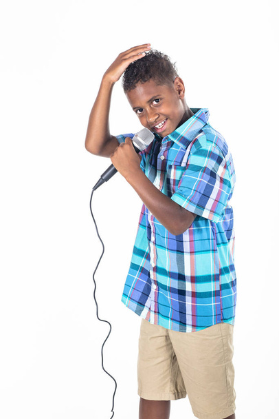 Confident and Talented young diverse singer singing and performing. Cute African American boy singing with emotion and performing on stage. Isolated on a white background - Photo, Image