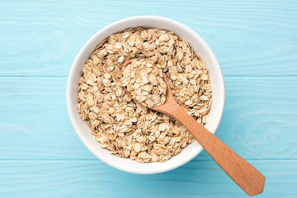 Rolled oats, oat flakes in bowl - Fotó, kép