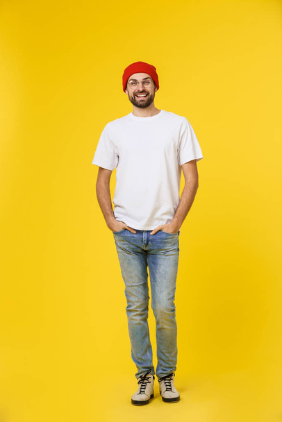 jeune homme hipster portant chapeau, bretelles, isoler sur fond jaune
. - Photo, image