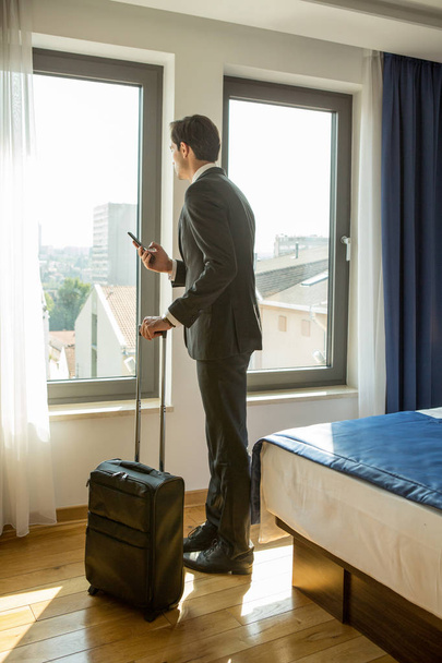 Businessman, pilot, looking through a hotel room window - Фото, зображення