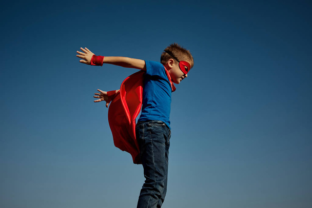 Superheldenkind (Junge) vor blauem Himmel - Foto, Bild
