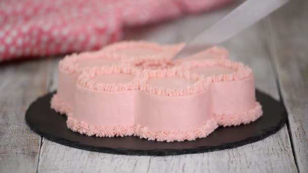 Las manos de las mujeres cortan el pastel con crema rosa en forma de flor
 - Metraje, vídeo