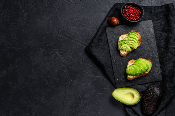 Avocado toast. Black background. Top view. Space for text - Foto, immagini