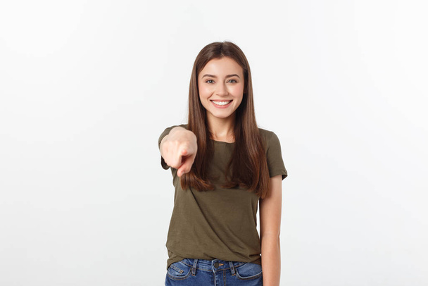 Porträt von attraktivem Lächeln lachendes Teenager-Mädchen, zeigt mit dem Finger, trägt grünes Hemd, weiße Zähne, braunes langes Haar, isoliert über weißem Hintergrund. - Foto, Bild