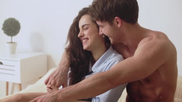 Closeup smiling couple watching laptop together. Happy couple relaxing on bed - Metraje, vídeo