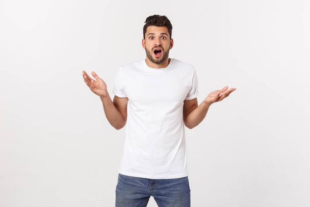 muž křičící ústa otevřená, držet hlavu ruku, nosit ležérní bílé tričko, izolované bílé pozadí, koncept tvář emoce - Fotografie, Obrázek
