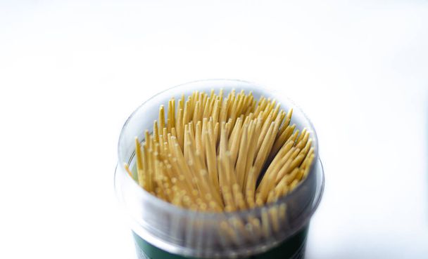 Toothpicks in a jar on a white background. Macro photo. Scattered on the table. - 写真・画像