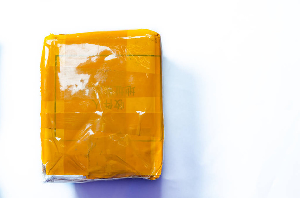 Un paquete amarillo del extranjero. Caja amarilla, cinta adhesiva amarilla de china
  - Foto, Imagen