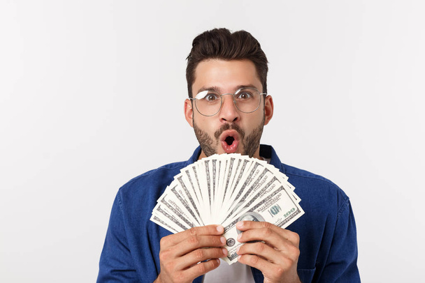 aantrekkelijke man houdt contant geld in de ene hand, op geïsoleerde witte achtergrond - Foto, afbeelding
