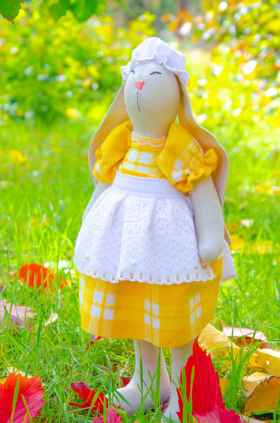 Handmade toy hare. Bunny mistress do it yourself from natural materials. Toy bunny in a dress and a hat. Decor macro. - Photo, Image