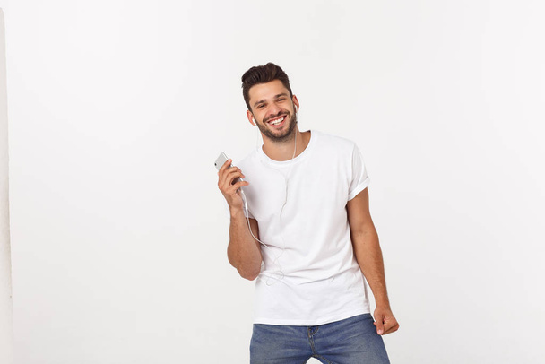 Hombre guapo casual bailando con teléfono móvil aislado sobre fondo blanco
 - Foto, Imagen