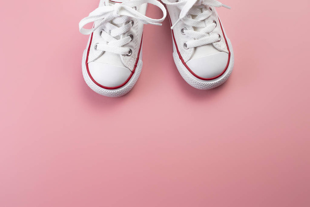 Photo of white sneakers over pink background. - Fotoğraf, Görsel