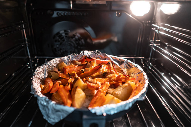 Patate al forno con carota e altre spezie in padella. - Foto, immagini