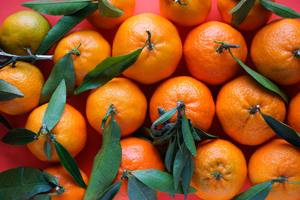 mandarini arancioni con foglie su sfondo arancione
. - Foto, immagini