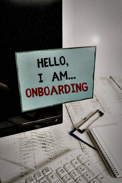 Writing note showing Hello I Am Onboarding. Business photo showcasing telling demonstrating that you are on ship or plane Note paper taped to black computer screen near keyboard and stationary. - Photo, Image