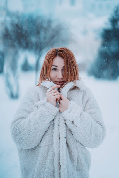 Portret vrouwelijk model buiten in eerste sneeuw - Foto, afbeelding