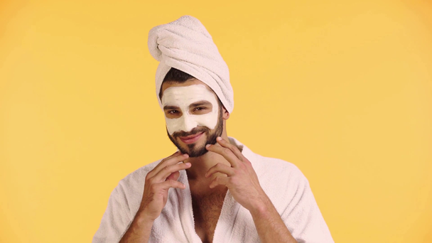 Mann mit Gesichtsmaske blickt in Kamera isoliert auf gelb - Filmmaterial, Video