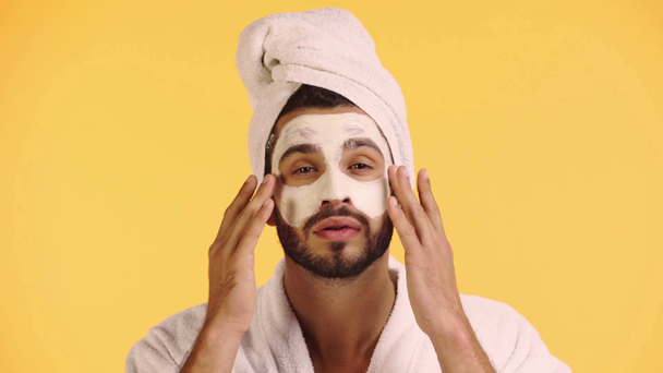 άνθρωπος που εφαρμόζει μάσκα προσώπου απομονωμένη σε κίτρινο - Πλάνα, βίντεο