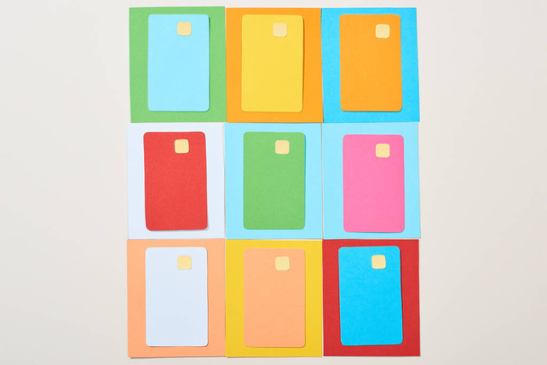 top view of multicolored empty credit cards on grey background - Foto, Bild