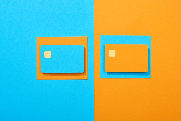 vista dall'alto di carte di credito vuote colorate su sfondo blu e arancione
 - Foto, immagini