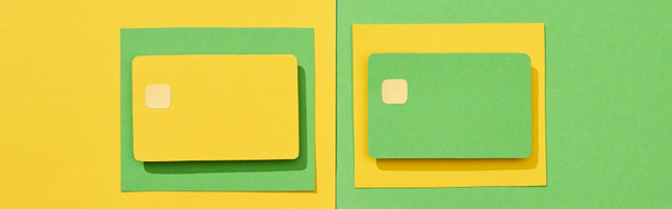 top view of empty credit cards on green and yellow background, panoramic shot - Fotó, kép