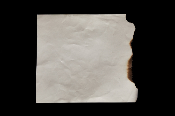 top view of empty burnt vintage paper isolated on black - Photo, Image