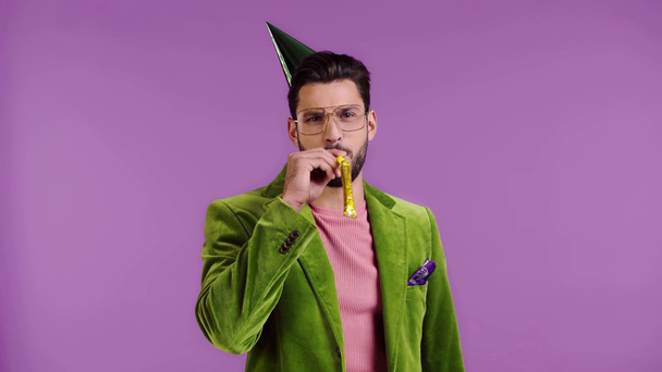 紫色で隔絶されたパーティーホーンで吹くベロアジャケットの男 - 映像、動画