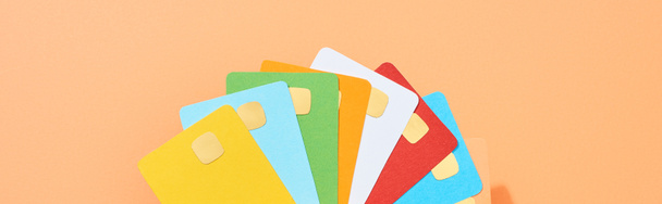 top view of multicolored empty credit cards on peach background, panoramic shot - Фото, изображение