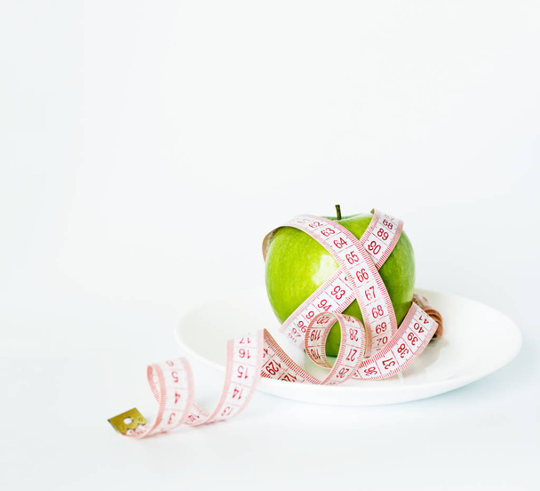 Vihreä omena kääritty senttimetrin nauha valehtelee
  - Valokuva, kuva